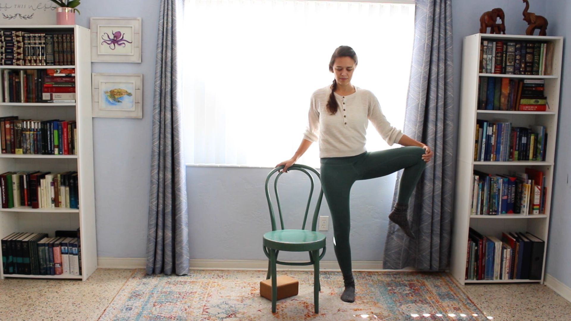 tree posture supported by a chair for strength and balance.